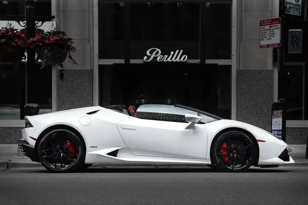 white Lamborghini parked in front of black building