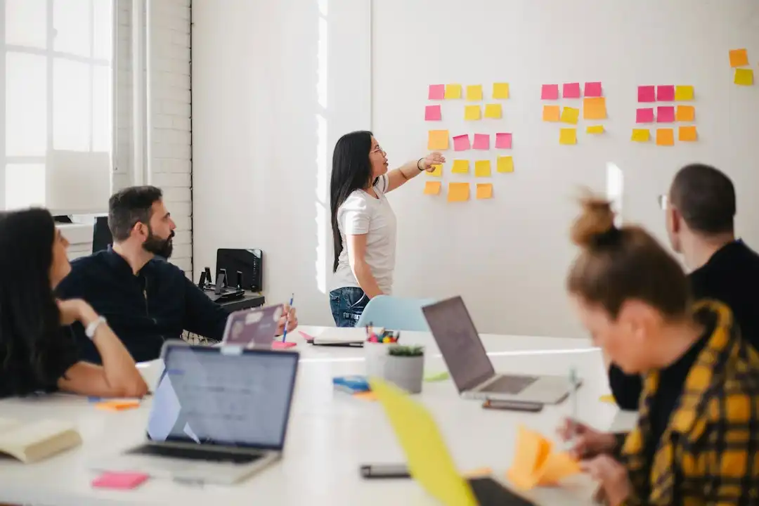 woman placing sticky notes on wall describing product and services